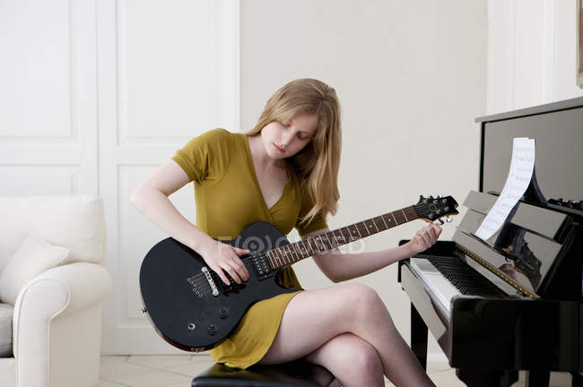 Chica adolescente tocando la guitarra eléctrica - foto de stock