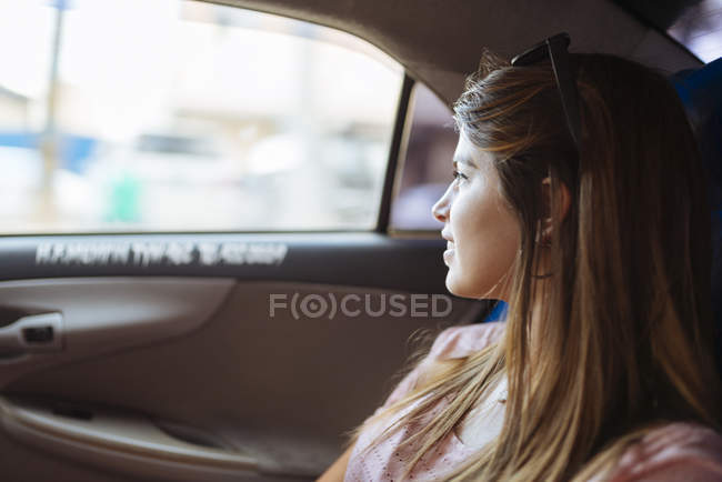 Giovane donna che guarda fuori dal finestrino del taxi, Manila, Filippine — Foto stock