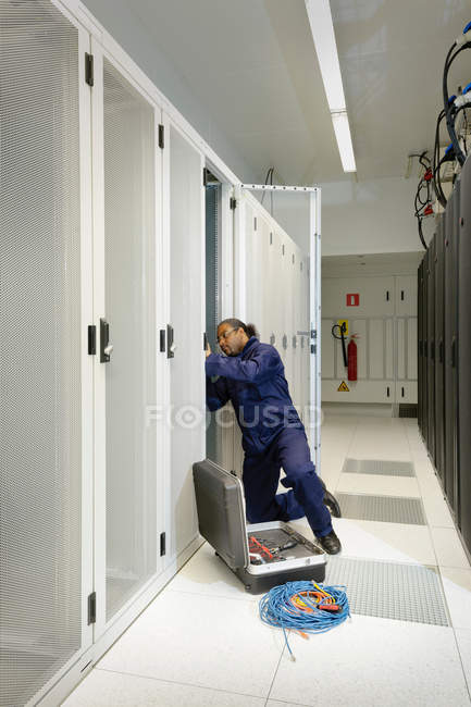 Técnico que trabaja en la sala de servidores - foto de stock