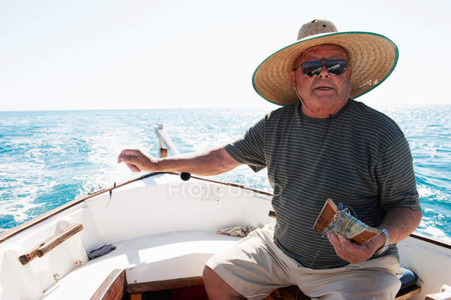 Pescador en el mar en barco de pesca - foto de stock