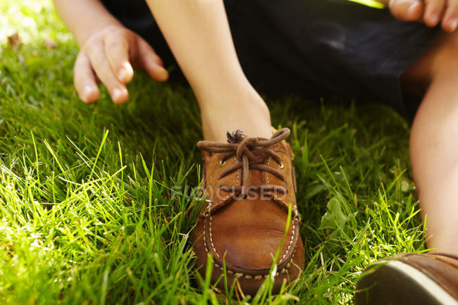 Acercamiento de cordones de zapatos de mocasín sobre hierba - foto de stock