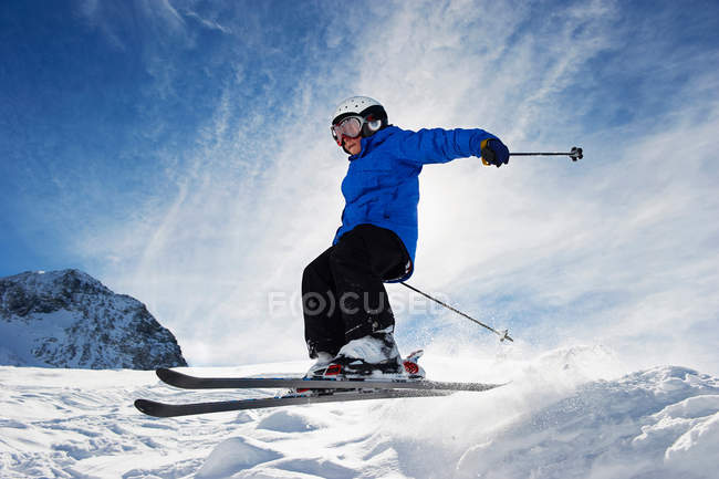 Хлопчик катається на лижах на засніжених горах — стокове фото