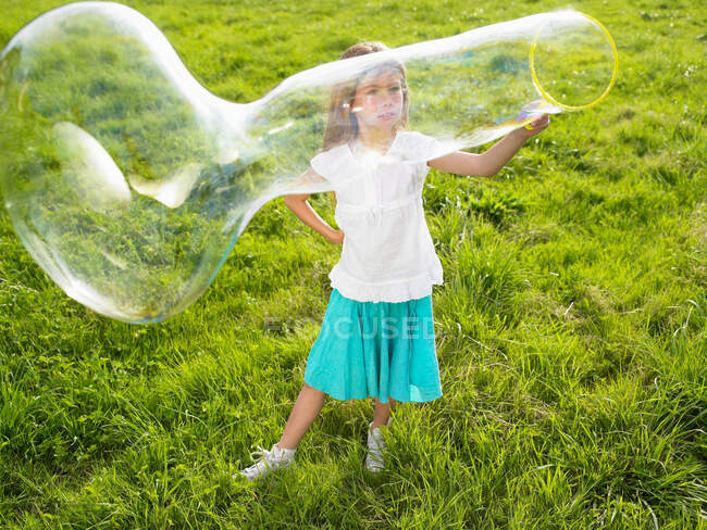 Little girl making soap bubbles — Stock Photo