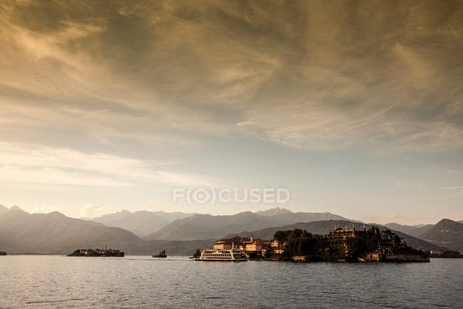 Mountains over rural village and lake — Stock Photo