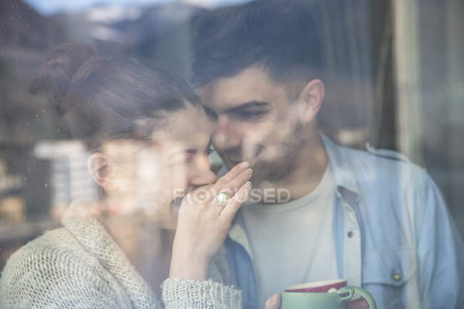Молода пара посміхається у віконному склі — стокове фото