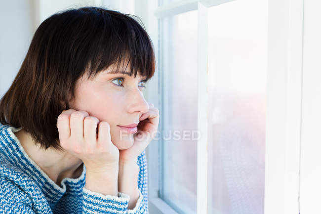 Woman resting chin in hands, focus on foreground — Stock Photo