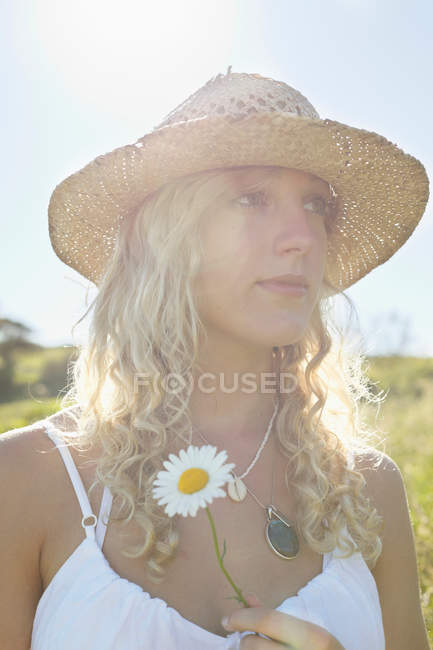 A girl in a field with a flower — Stock Photo