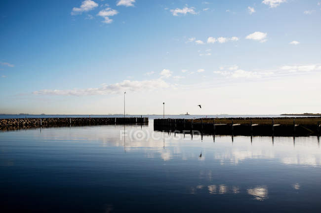 Cielo reflejado en aguas todavía portuarias - foto de stock