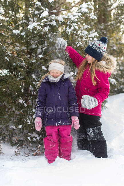 Sisters playing outside in the snow — Stock Photo