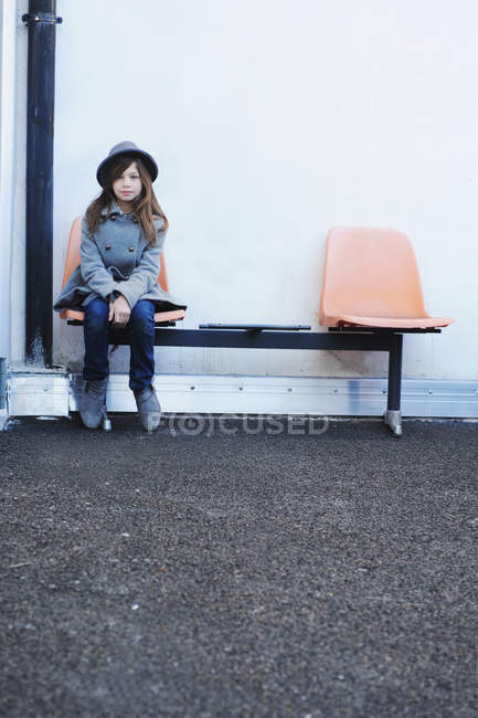 Дівчина сидить на стільці на відкритому повітрі — стокове фото