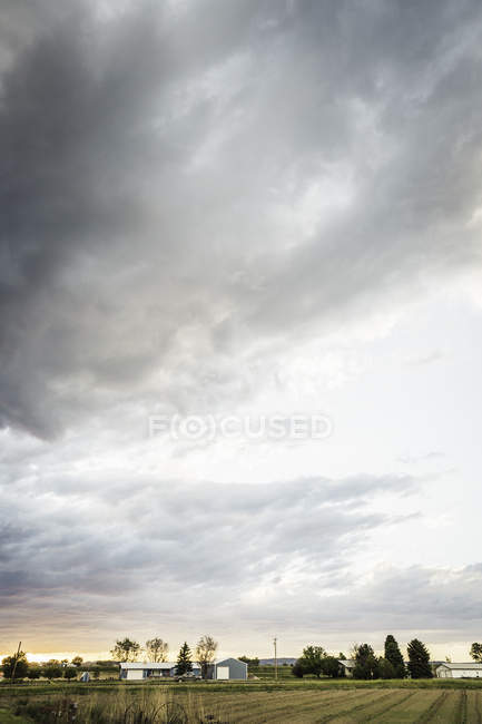 Felder und Gebäude unter dramatischem Himmel — Stockfoto