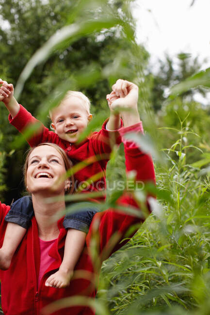 Mother carrying son on her shoulders — Stock Photo