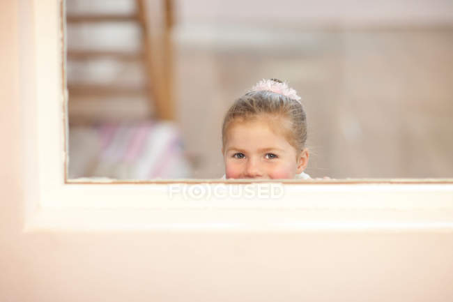 Young girl looking through window at ballet class — Stock Photo