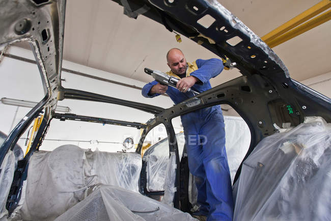 Mecânico de trabalho no carro na garagem — Fotografia de Stock