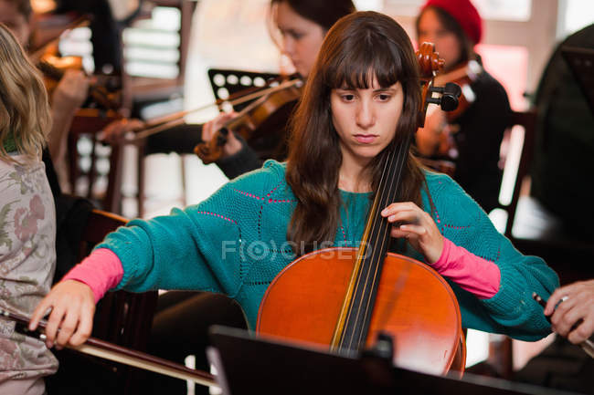 Игрок на виолончели тренируется с группой — стоковое фото