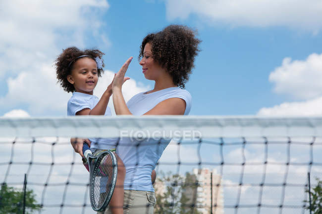 Mother and daughter high fiving on court — Stock Photo