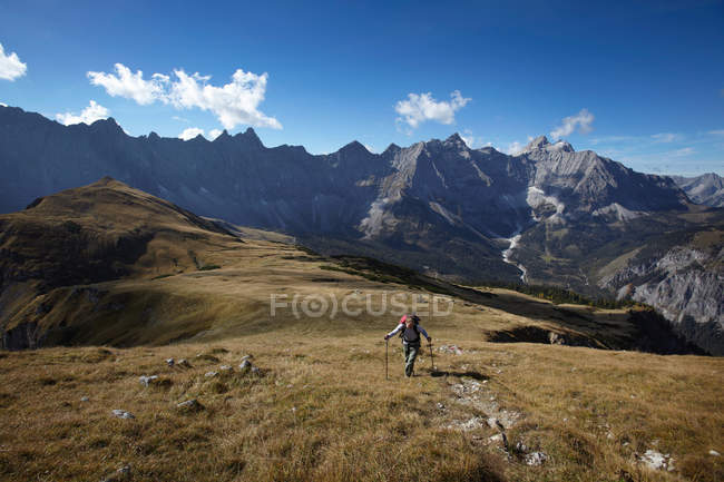 Hombre caminando en las montañas - foto de stock