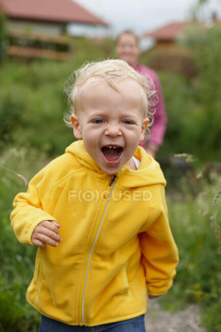 Niño pequeño riendo en el patio trasero - foto de stock