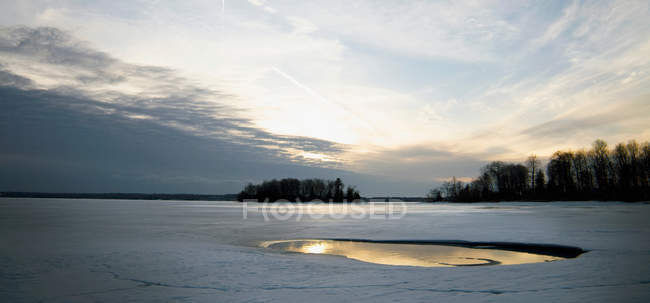 Coucher de soleil nuageux sur la glace fondante — Photo de stock