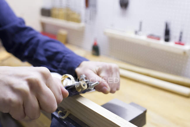 Carpinteiro feminino mãos aplainar madeira na oficina — Fotografia de Stock