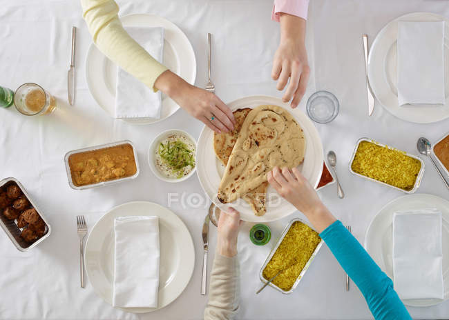 Menschenhände beim Brotholen am Tisch — Stockfoto