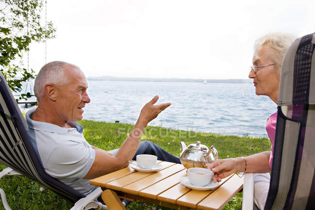 Senior man and woman in deck chairs — Stock Photo