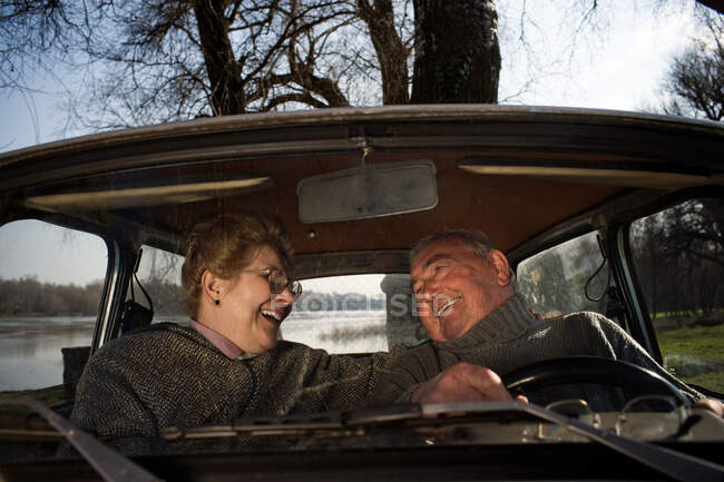 Seniorenpaar lächelt im Auto — Stockfoto