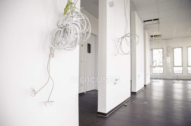 Câbles réseau et d'alimentation suspendus au nouveau plafond de bureau — Photo de stock