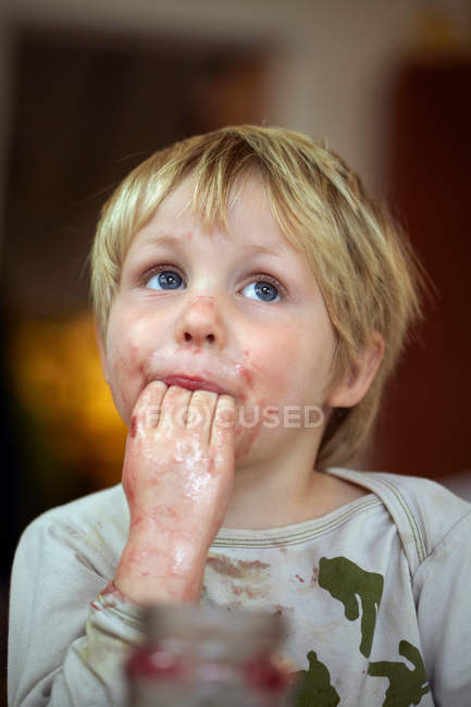 Junge leckt Marmelade aus Fingern — Stockfoto