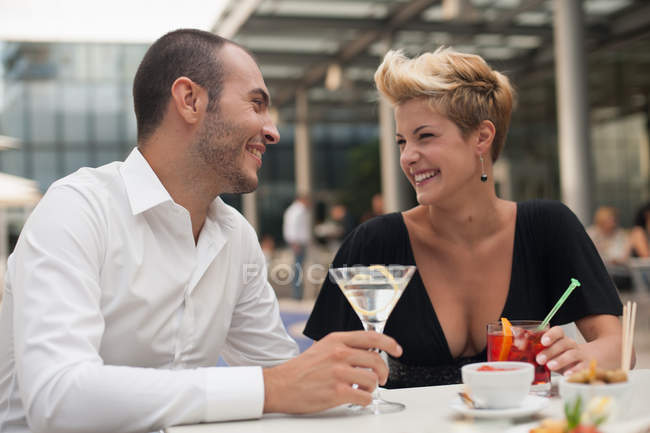 Улыбающаяся пара выпивает на открытом воздухе — стоковое фото