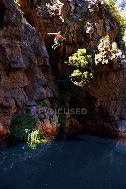 Homem penhasco pulando na piscina — Fotografia de Stock