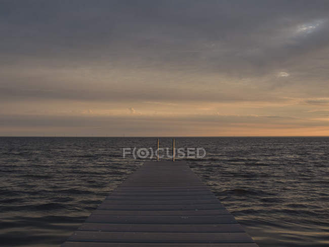 Морський пейзаж з пірсом на сході сонця — стокове фото
