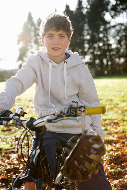 Niño montar en bicicleta en el prado - foto de stock