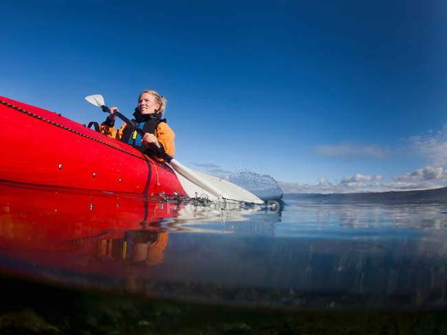 Жінка на байдарці в нерухомому озері — стокове фото