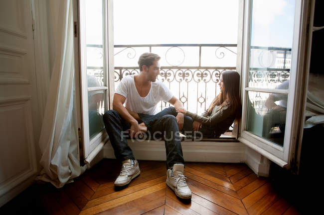 Couple assis dans le rebord de la fenêtre, foyer sélectif — Photo de stock