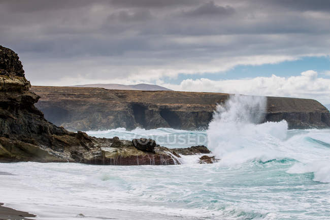 Waves crashing on rocky cliffs — Stock Photo