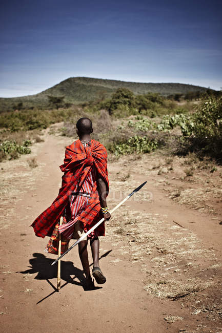 Maasai uomo a piedi su strada sterrata — Foto stock