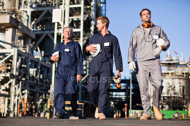 Travailleurs marchant à la raffinerie de pétrole — Photo de stock