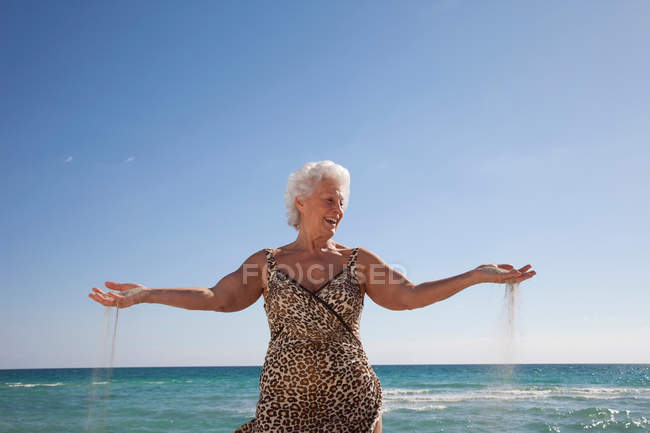 Mujer mayor en la playa - foto de stock