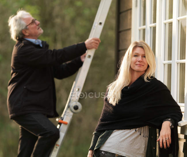 Donna sorridente mentre marito scalare la scala — Foto stock