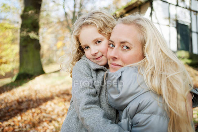 Madre e hija abrazándose al aire libre - foto de stock