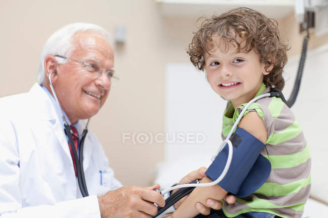 Médico examinando chico en la oficina - foto de stock