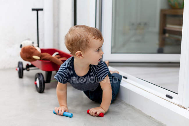 Boy crawling out back door — Stock Photo