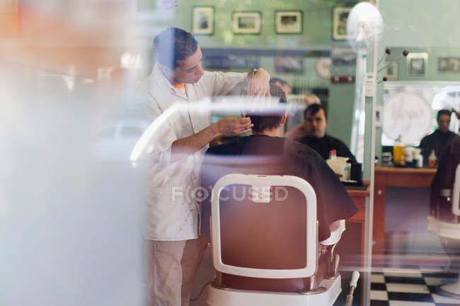 Barbeiro trabalhando no cliente na loja — Fotografia de Stock