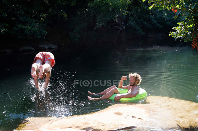Двое мужчин играют в реке — стоковое фото