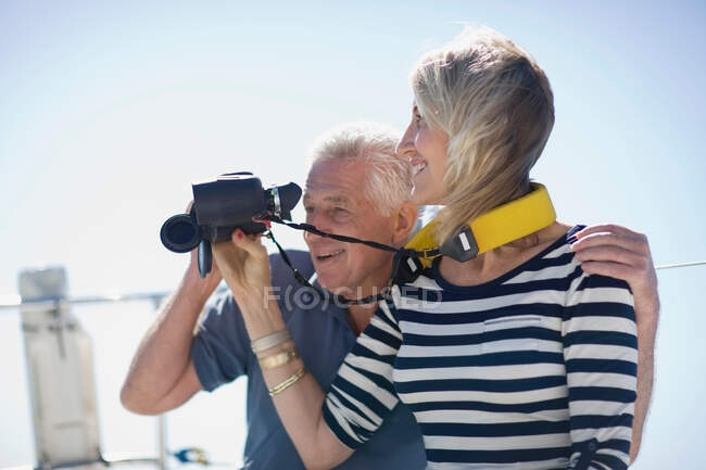 Casal mais velho usando binóculos no barco — Fotografia de Stock