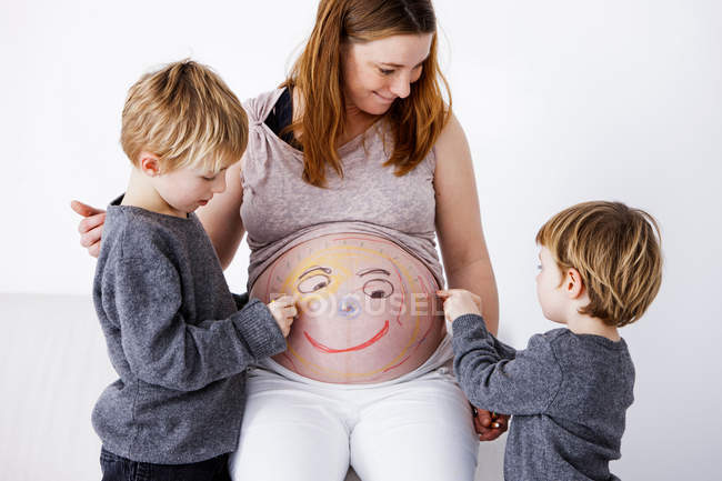 Children drawing on pregnant mother — Stock Photo