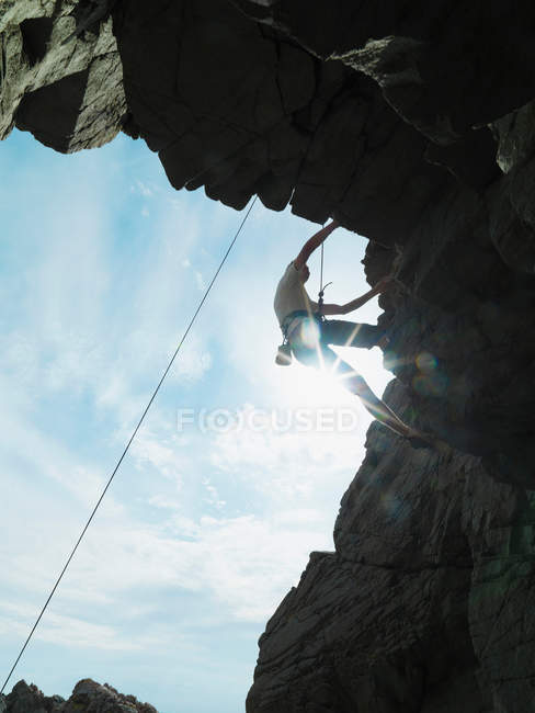 Скелястий альпініст масштабує круте скелясте обличчя — стокове фото