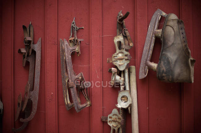 Vintage ice skates hanging on red wall — Stock Photo