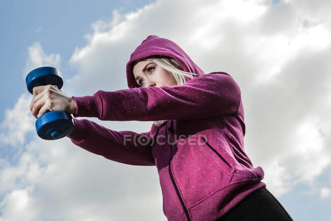 Молодая женщина с помощью гирь для рук — стоковое фото